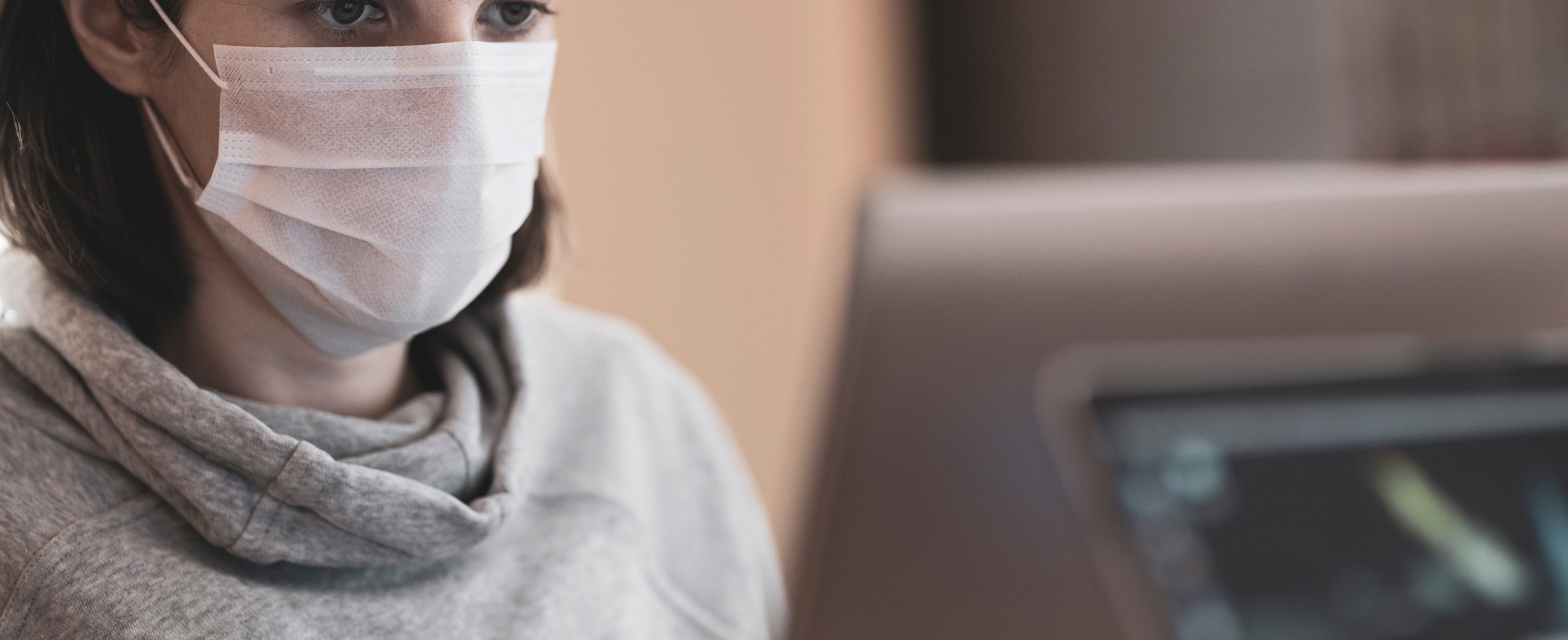 Woman wearing face mask while using computer