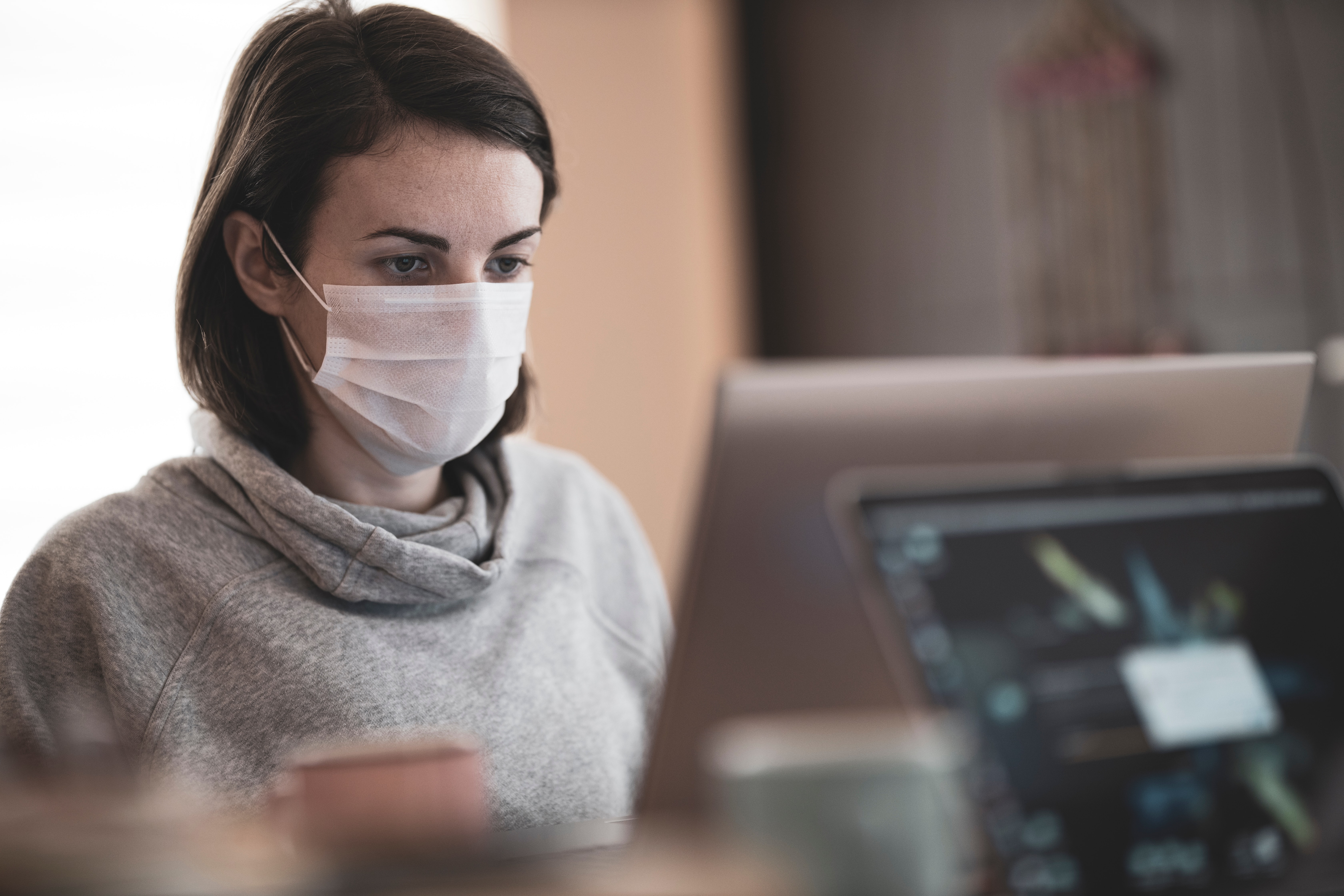 Woman wearing face mask while using computer